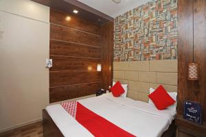 ein Schlafzimmer mit einem Bett mit roten Kissen darauf in der Unterkunft Hotel Marina Near Cit Road Ladies Park, Park in Tangra