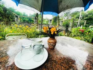 einen Tisch mit zwei Platten und eine Vase mit Blumen in der Unterkunft Luxury Villa Siena with Private Pool! in Puducherry