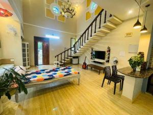 ein Wohnzimmer mit einem Bett in einem Zimmer mit einer Treppe in der Unterkunft Luxury Villa Siena with Private Pool! in Puducherry
