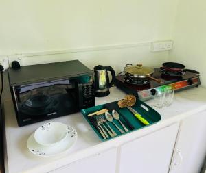 una encimera de cocina con microondas y una mesa con una placa. en The Loft, en Midigama East