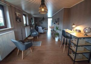 Vakantiewoning - ‘t Ouwershuys في Opoeteren: غرفة معيشة فيها طاولة وكراسي