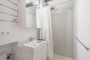 a white bathroom with a sink and a shower at Se Teulere in Fornalutx