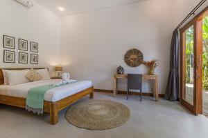 a bedroom with a bed and a table and a window at Pulesari 2 bedrooms in Seminyak +27 photos