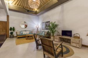 a living room with a couch and a television at Pulesari 2 bedrooms in Seminyak