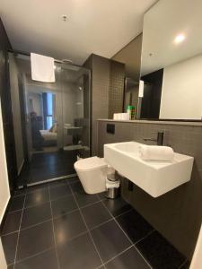 y baño con lavabo y aseo. en 2 Bed 2 Bath Luxury Apartment in Braddon Canberra - Free heated pool, gym, parking, en Canberra
