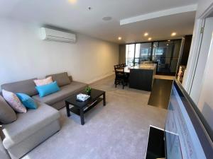 sala de estar con sofá y mesa en 2 Bed 2 Bath Luxury Apartment in Braddon Canberra - Free heated pool, gym, parking, en Canberra