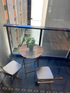 a balcony with a table and two chairs and a window at 2 Bed 2 Bath Luxury Apartment in Braddon Canberra - Free heated pool, gym, parking in Canberra