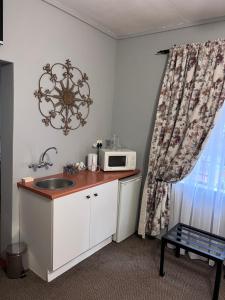 a kitchen with a sink and a microwave on a counter at Big Tree Midrand in Midrand