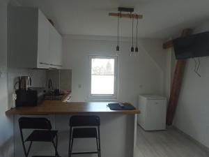 a kitchen with a counter and some chairs in it at Apartament Wolności in Jelenia Góra