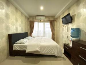 a bedroom with a bed and a television in it at Deluxe Suites Skyview with Infinity Pool in Sunggal