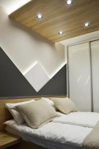 Bett in einem Zimmer mit einer Fensterwand in der Unterkunft Borovi snovi Divčibare in Divčibare + 20 Fotos