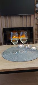 due bicchieri da vino seduti sopra un tavolo di Borovi snovi Divčibare a Divčibare