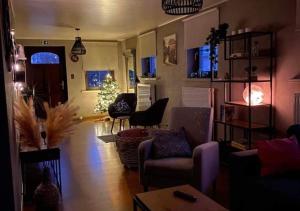 een woonkamer met een kerstboom op de achtergrond bij Vakantiewoning - ‘t Ouwershuys in Opoeteren