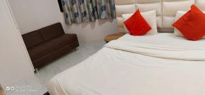 1 dormitorio con cama con almohadas rojas y sofá en hotel shreenivas en Ahmedabad