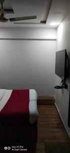 Schlafzimmer mit einem Bett und einem Flachbild-TV in der Unterkunft hotel shreenivas in Ahmedabad