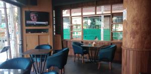 un restaurante con 2 mesas, sillas y ventanas en Best Corner Pattaya, en Pattaya South