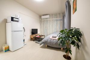 a small room with a bed and a refrigerator at ミニマリズムホテル葛飾 in Tokyo