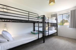 2 Etagenbetten in einem Zimmer mit Fenster in der Unterkunft Abode Mooloolaba, Backpackers & Motel rooms in Mooloolaba