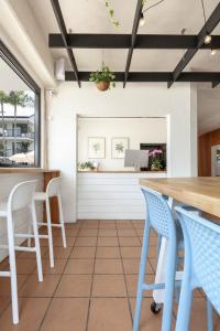 a dining room with blue chairs and a table at Abode Mooloolaba, Backpackers & Motel rooms in Mooloolaba
