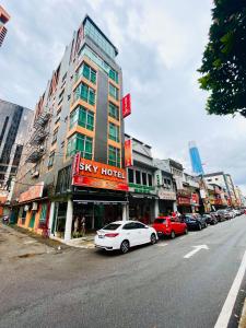 una strada cittadina con auto parcheggiate di fronte a un edificio di Sky Hotel @ Pudu a Kuala Lumpur