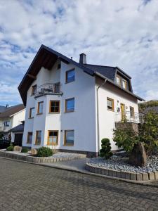 uma casa branca com um telhado preto em Ferienwohnung Moselzeit em Alken