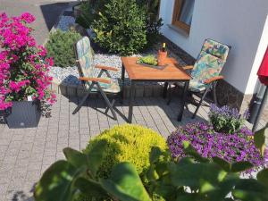 a patio with a table and chairs and flowers at Ferienwohnung Moselzeit in Alken