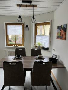 阿爾肯的住宿－Ferienwohnung Moselzeit，一间带木桌和椅子的用餐室