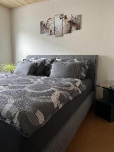 a bed in a bedroom with two paintings on the wall at Ferienwohnung Moselzeit in Alken