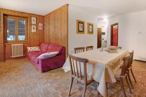 a living room with a table and a red couch at Casa Rossella in Bormio