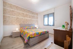 ein Schlafzimmer mit einem Bett mit einer bunten Bettdecke in der Unterkunft Casa Tovini in Pisogne