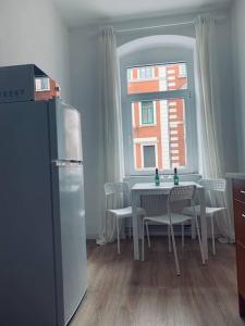 una cucina con tavolo, sedie e finestra di work & travel apartment a Meißen