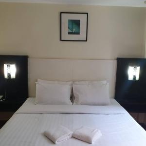 um quarto com uma cama branca e 2 almofadas brancas em Zen Hotel @18 em Banguecoque