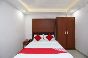 - une chambre avec un grand lit et des oreillers rouges dans l'établissement Kamat Inn, à Bankipur