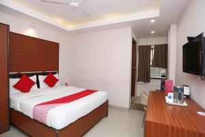 a bedroom with a bed with red pillows and a desk at Kamat Inn in Bankipur