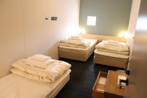 a room with three beds in a room at Hostel Tomar in Furano