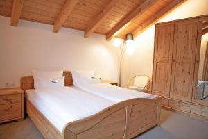 a bedroom with a large wooden bed with white sheets at Apt Lara Ruveda in Ortisei