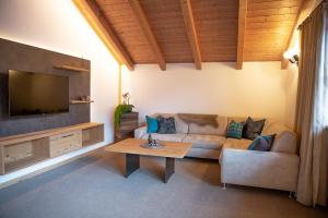 a living room with a couch and a tv at Apt Lara Ruveda in Ortisei