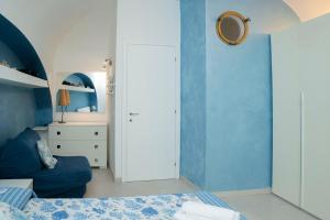 una camera da letto con pareti blu, un letto e uno specchio di 063 - Casa del Corso, Centrale 200m dal mare e spiaggia a Sestri Levante