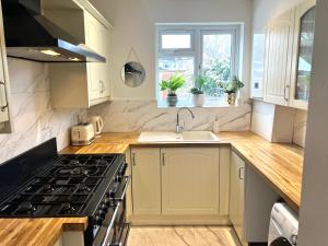 a kitchen with a sink and a stove top oven at Modern Double Room with Fire TV in Bromley