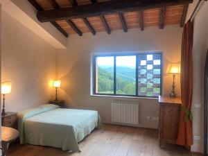 um quarto com uma cama e uma grande janela em Podere Capitignano em Borgo San Lorenzo