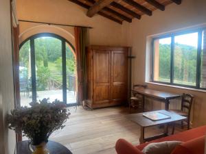a living room with a table and a large window at Podere Capitignano in Borgo San Lorenzo