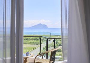 balcón con 2 sillas y vistas al océano en Lanyang Seaview Hotel en Toucheng