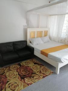 1 dormitorio con 1 cama y 1 sofá sobre una alfombra en Mombasa City Center Studio en Mombasa