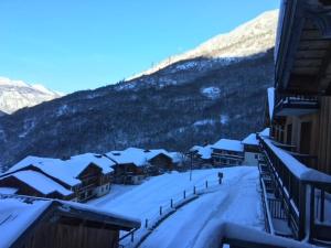 wioska pokryta śniegiem z górą w tle w obiekcie Orelle - Val Thorens, le Hameau des eaux - SPA & piscine w mieście Orelle