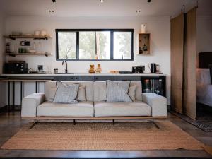 a white couch in a living room with a window at Wagyu Mountain Lodge in Paarl