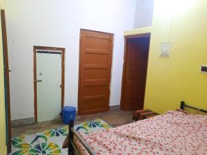 a bedroom with a bed and two doors at Dden Vennell 2-homestay close to Metro in Kolkata