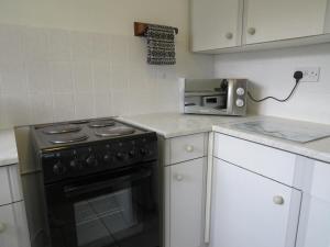 La cocina está equipada con fogones y tostadora. en Remarkable and perfect 3 Bed House in Nottingham en Nottingham