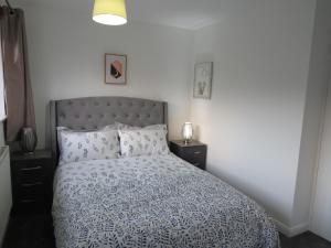 um quarto com uma cama com um edredão azul e branco em Remarkable and perfect 3 Bed House in Nottingham em Nottingham