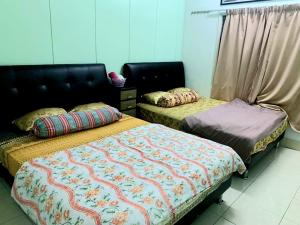 two beds sitting next to each other in a room at Sakura Guest House in Cameron Highlands