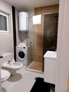 a bathroom with a washing machine and a washer at Apartman River Una in Bihać